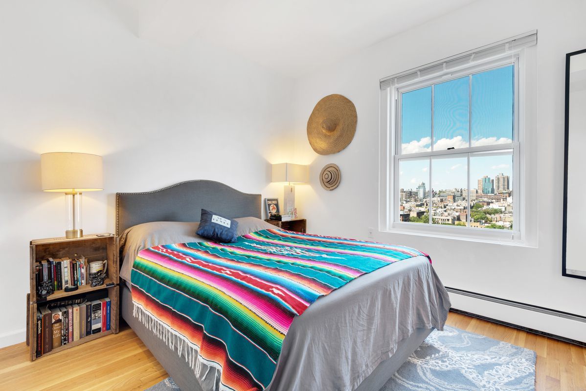 143 Avenue B, Unit 12E Manhattan, NY 10009 - Photo 4 of 8 a bedroom with bed and a window