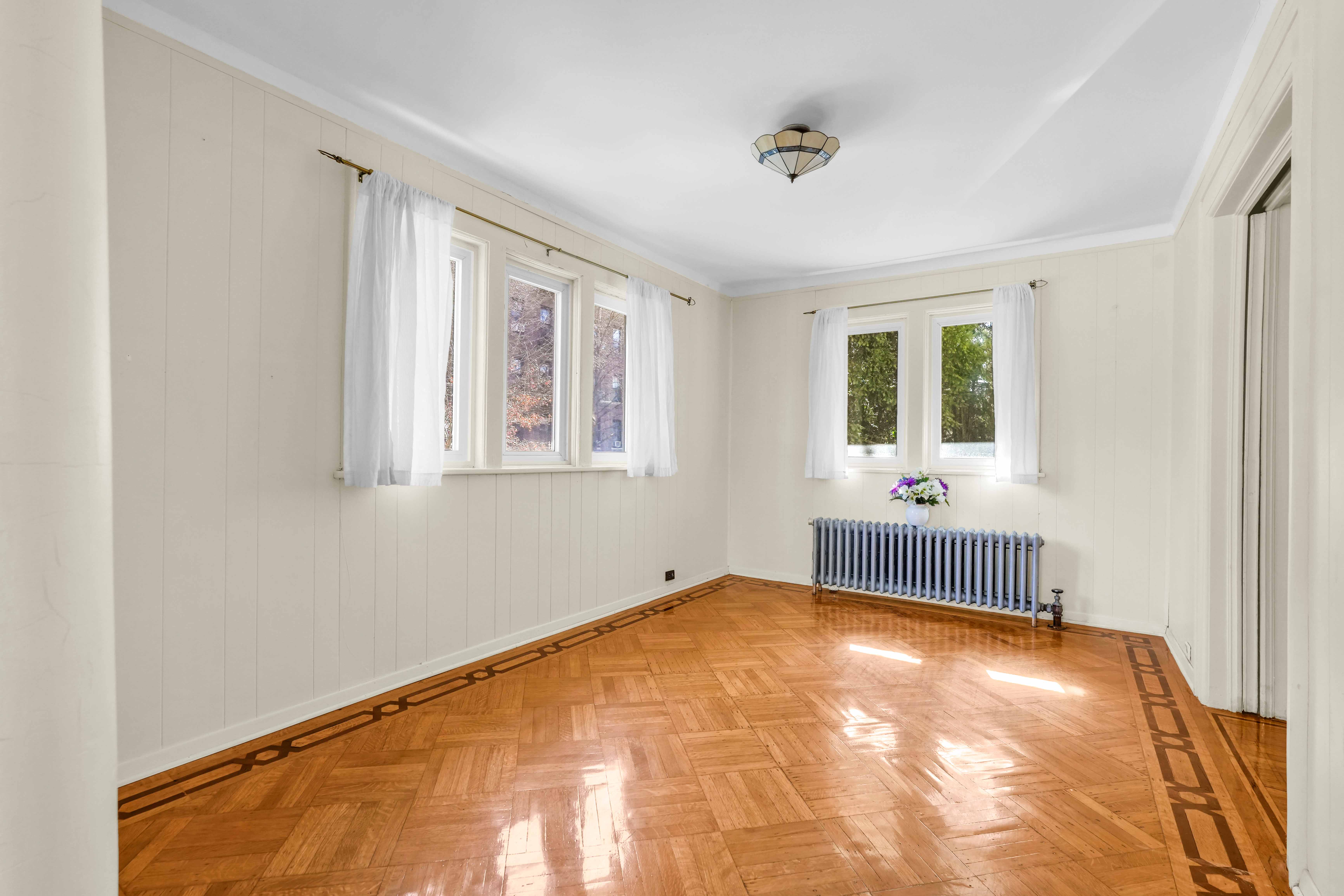 642 East 26th Street Brooklyn, NY 11210 - Photo 3 of 32 a view of an empty room with wooden floor and a window