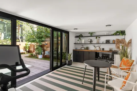 a living room with furniture a rug and a floor to ceiling window