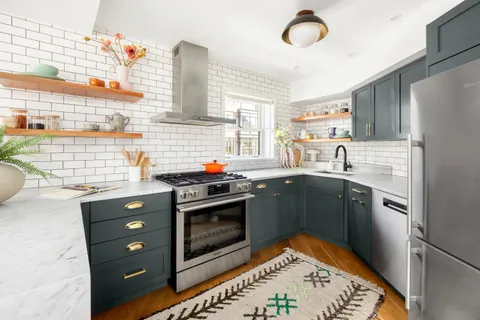 a kitchen with stainless steel appliances granite countertop a stove a sink and a refrigerator