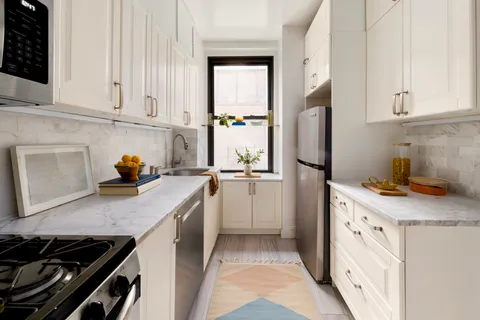a kitchen with white cabinets and appliances