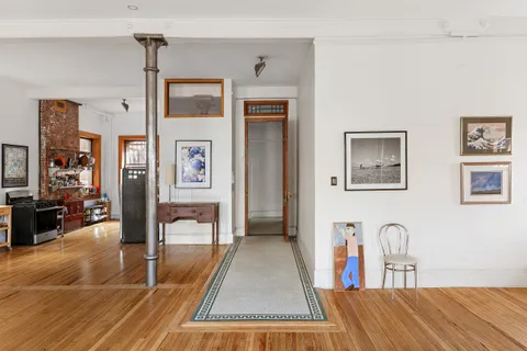 a living room with furniture a large window wooden floor and a table
