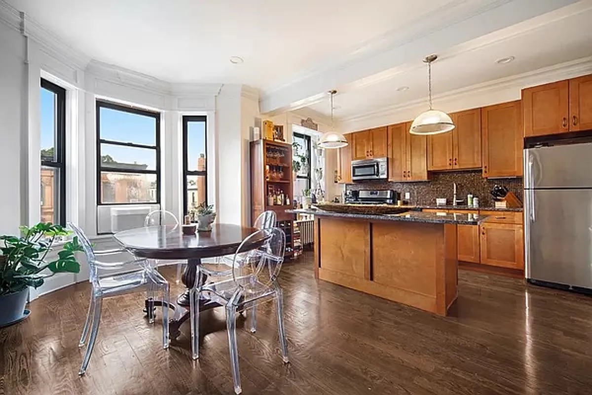 320 7th Avenue, Unit 1 Brooklyn, NY 11215 - Photo 2 of 7 a kitchen with stainless steel appliances granite countertop a table chairs refrigerator and microwave