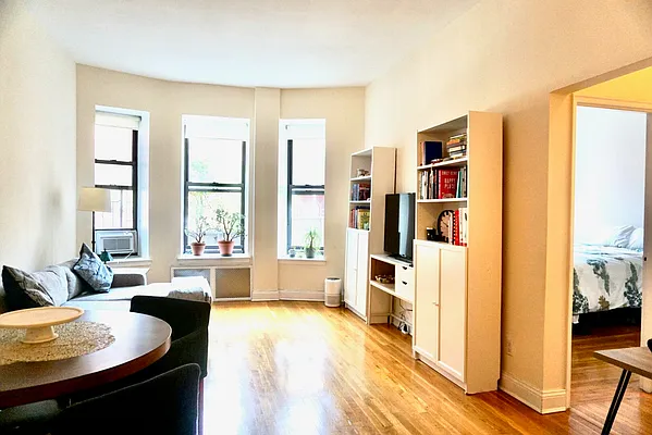 30 East 95th Street, Unit 2E Manhattan, NY 10128 - Photo 1 of 6 a living room with furniture and a large window