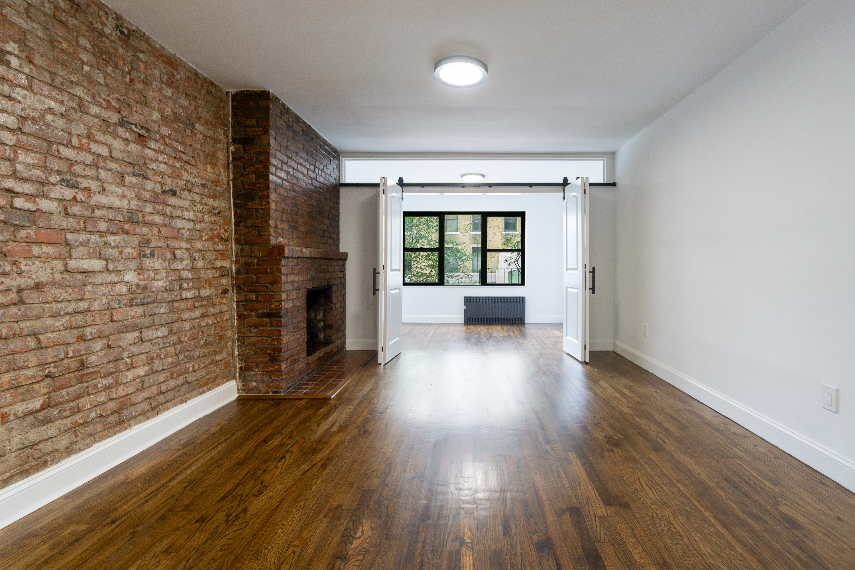 205 2nd Avenue, Unit 3B Manhattan, NY 10003 - Photo 2 of 9 wooden floor in an empty room with a fireplace
