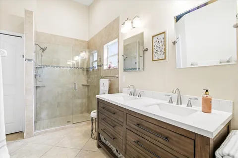 a bathroom with a sink shower and a mirror