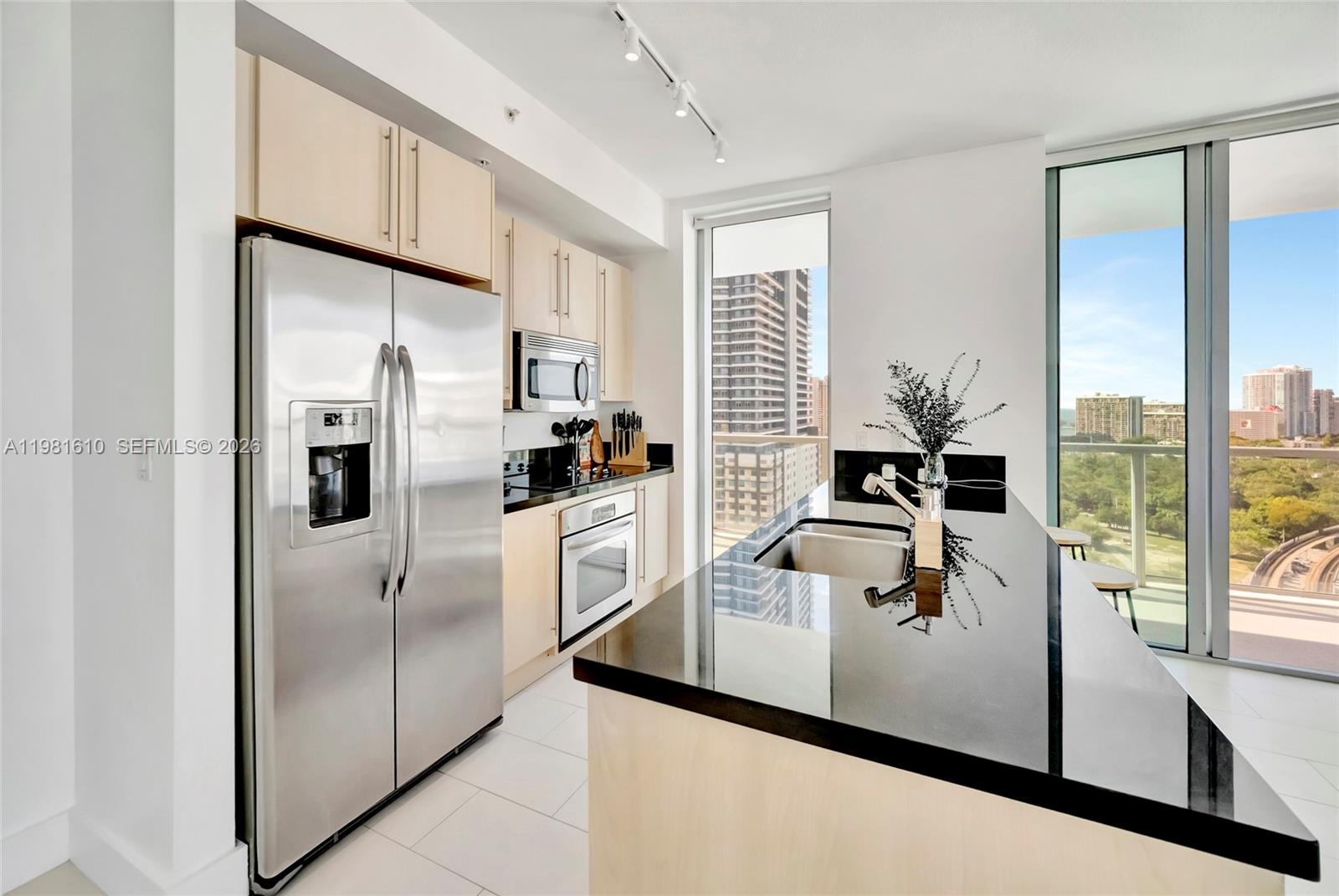 79 Southwest 12th Street, Unit 2201S Miami, FL 33130 - Photo 4 of 33 a kitchen with stainless steel appliances a refrigerator a sink and white cabinets