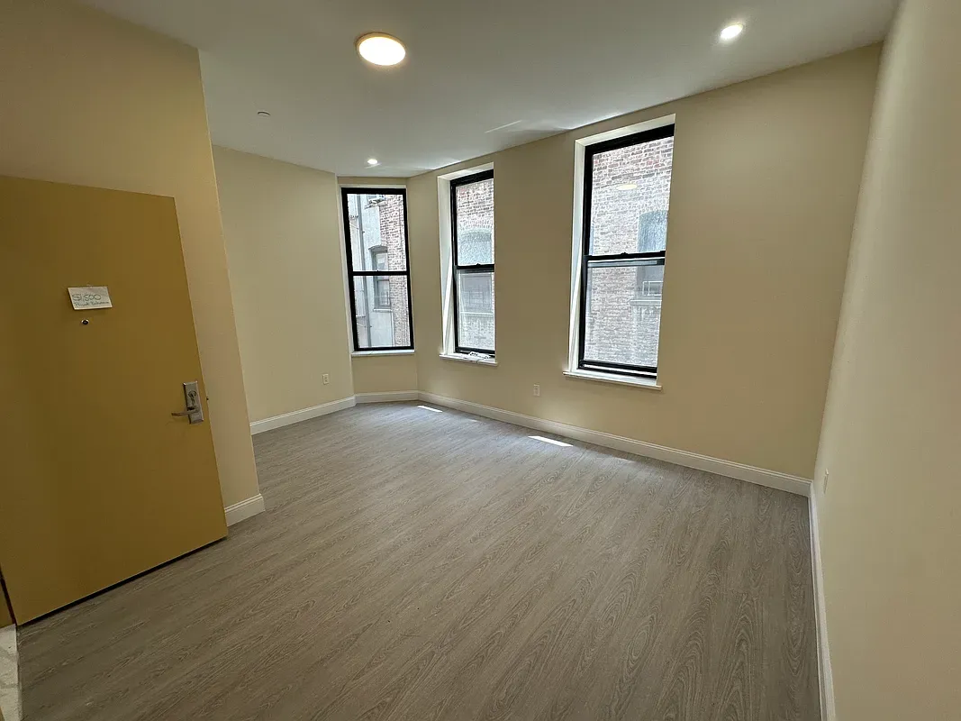 an empty room with windows and closet