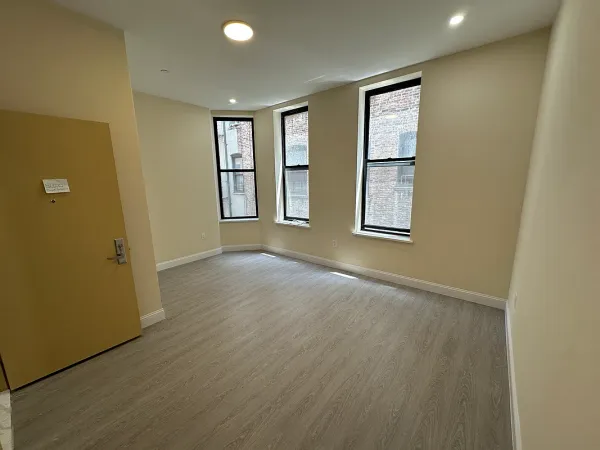 an empty room with windows and closet