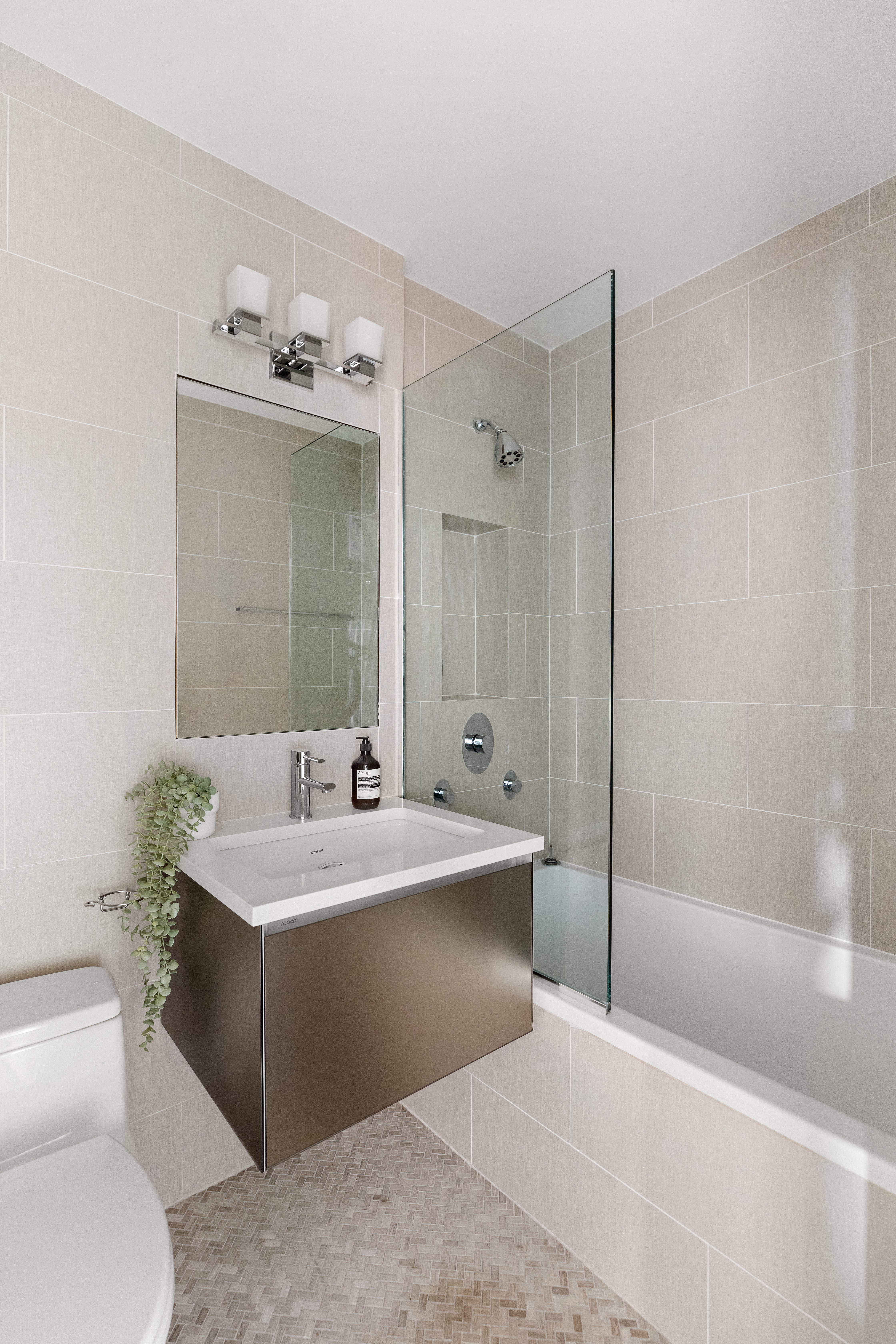 225 East 57th Street, Unit 9M Manhattan, NY 10022 - Photo 7 of 10 a bathroom with a sink mirror toilet and bathtub