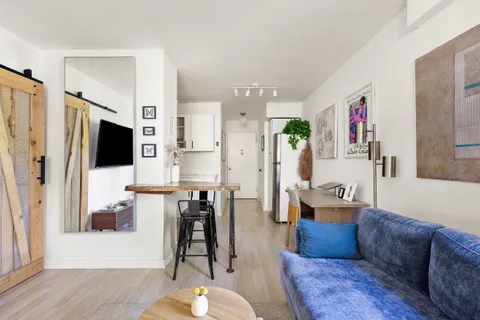 a living room with furniture wooden floor and a flat screen tv