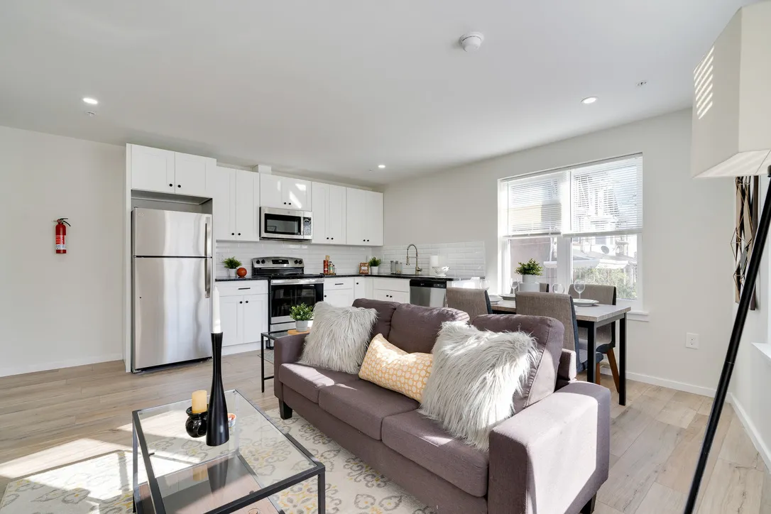 a living room with furniture a wooden floor and a large window