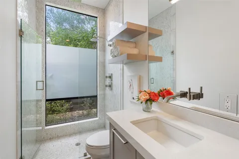a bathroom with a sink vanity mirror and toilet