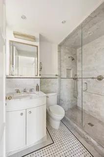 a bathroom with a granite countertop sink a toilet and a mirror