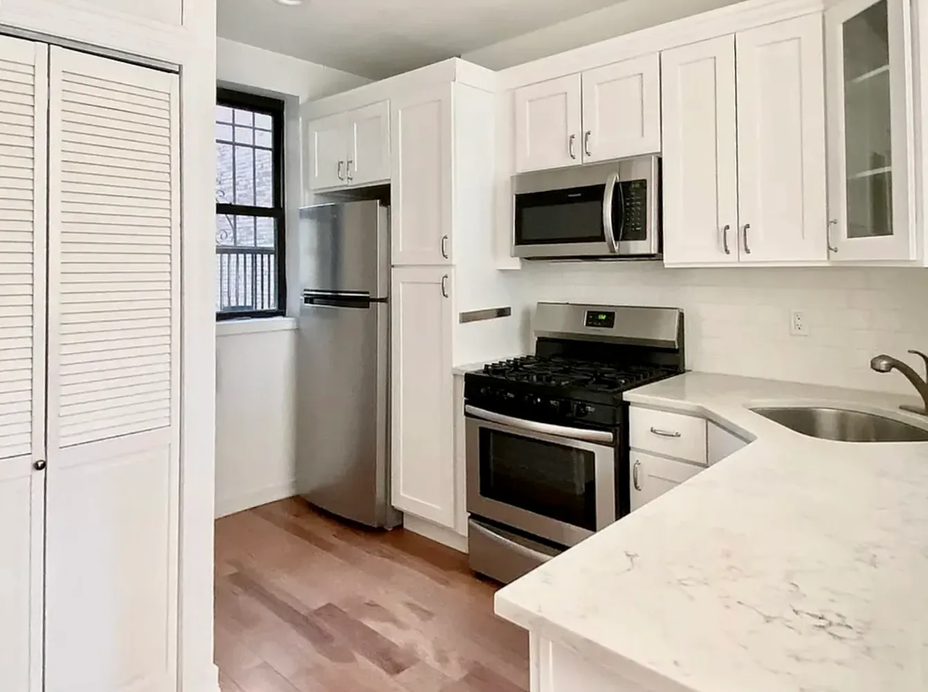 a kitchen with stainless steel appliances granite countertop a stove microwave and refrigerator