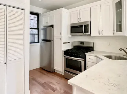 a kitchen with stainless steel appliances granite countertop a stove microwave and refrigerator