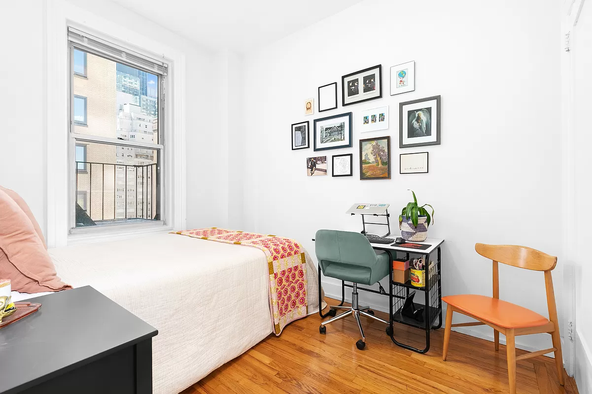 57 West 58th Street, Unit 8E Manhattan, NY 10019 - Photo 5 of 8 a bedroom with a bed and a table in it