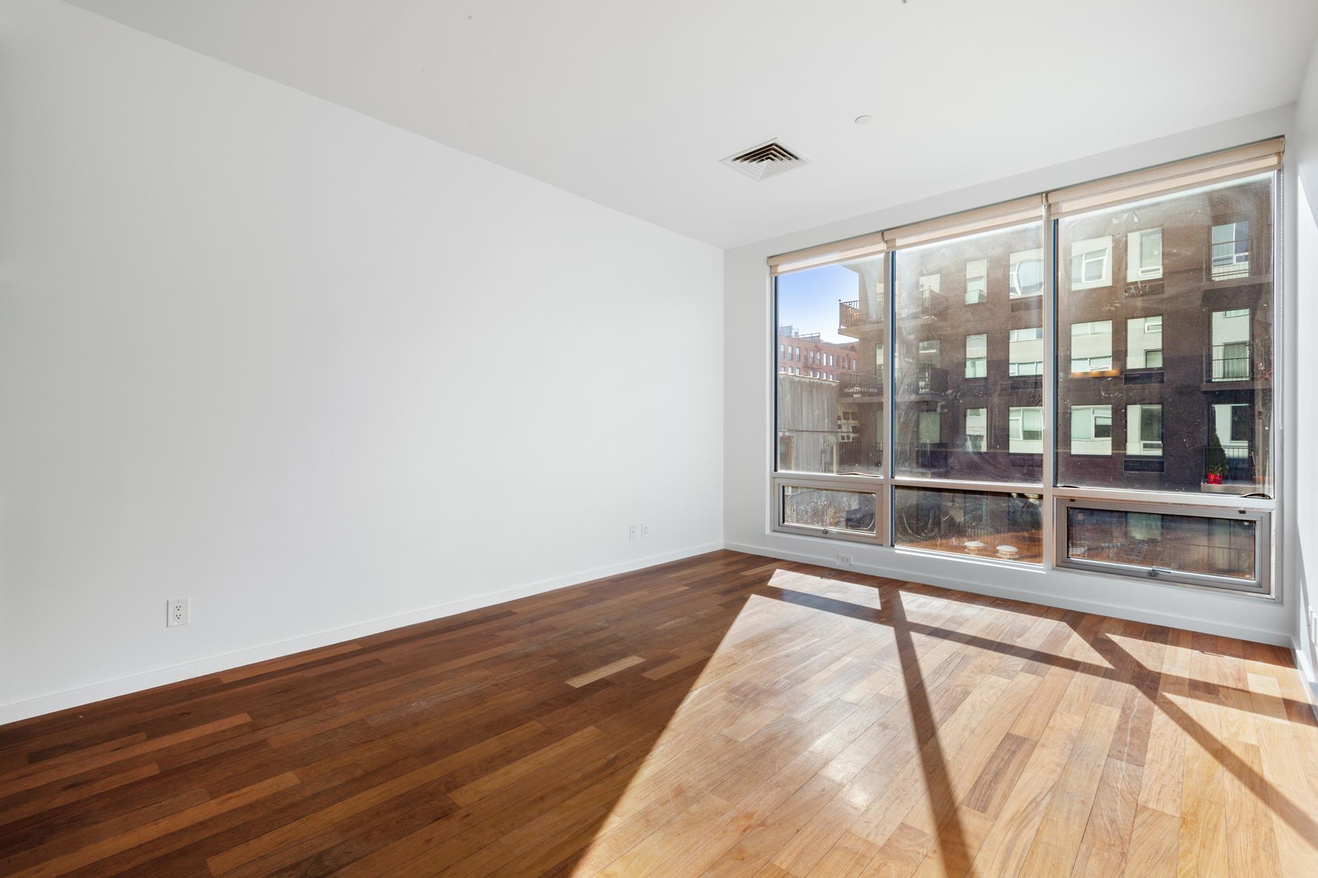 170 North 11th Street, Unit 3F Brooklyn, NY 11211 - Photo 3 of 9 a view of an empty room with a balcony and wooden floor