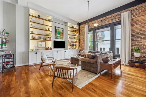 a living room with furniture wooden floor and a flat screen tv