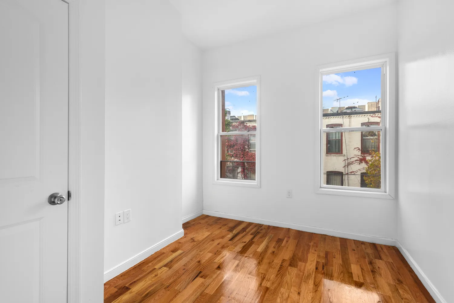 a view of a bedroom with wooden floor and windows