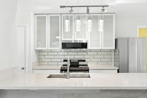 a view of kitchen with sink and refrigerator
