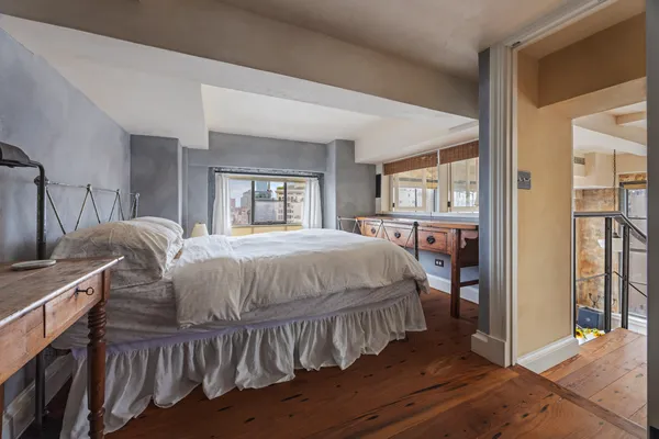 a bedroom with a bed and large windows