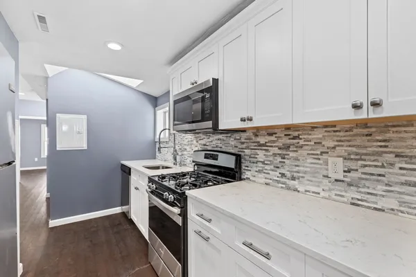 a kitchen with granite countertop cabinets stainless steel appliances and a sink