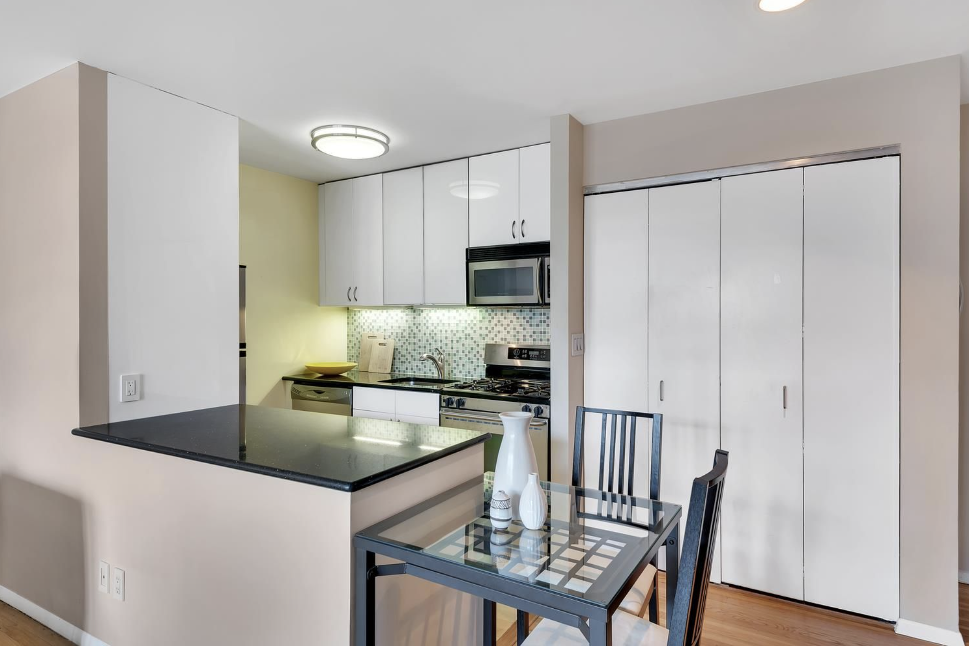 445 West 19th Street, Unit 5G Manhattan, NY 10011 - Photo 3 of 7 a kitchen with kitchen island a large counter top space appliances and cabinets