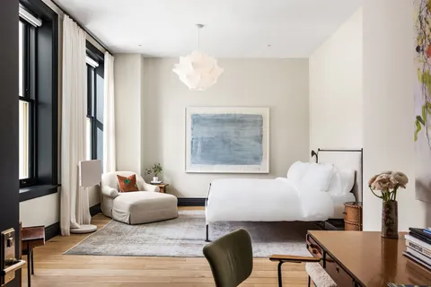 a bedroom with furniture and a large window