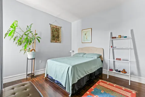 a bedroom with a bed and a potted plant