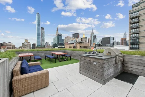 a view of a roof deck with couches and city view