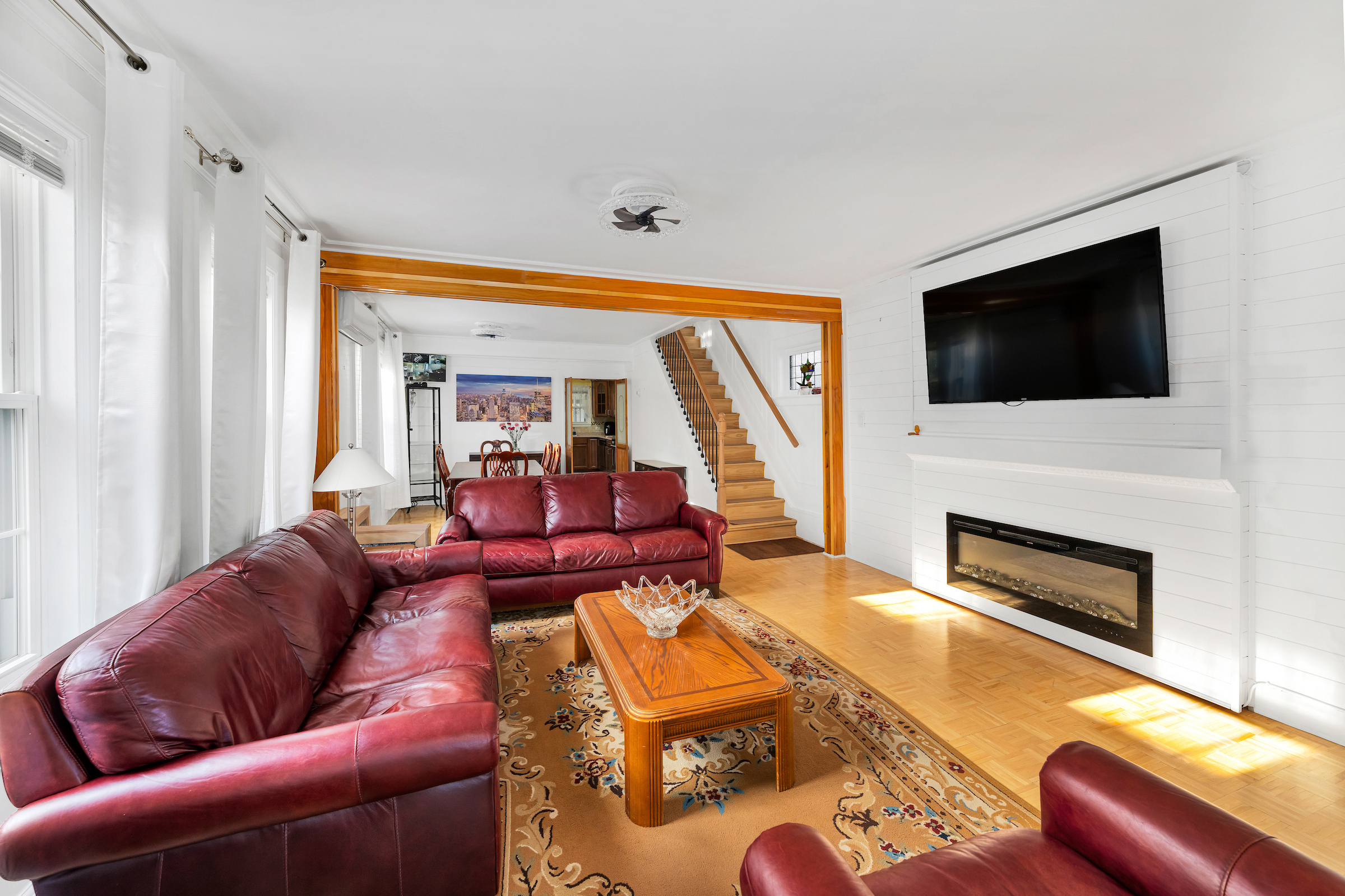 132-11 107th Avenue Queens, NY 11419 - Photo 2 of 14 a living room with furniture a fireplace and a flat screen tv