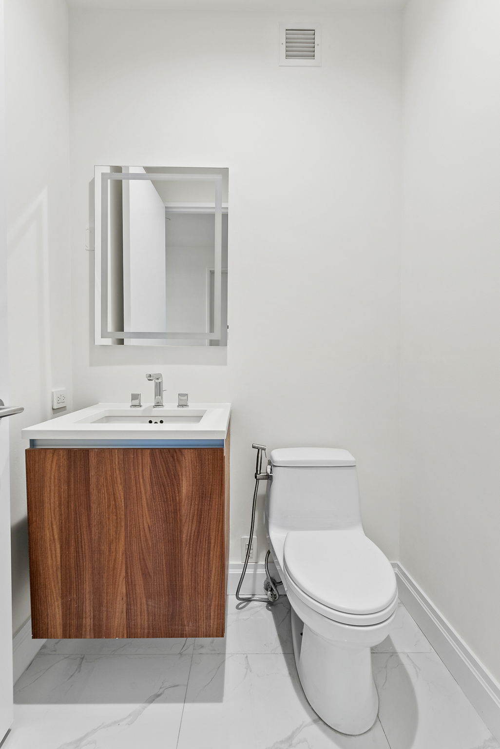 845 United Nations Plaza, Unit 63D Manhattan, NY 10017 - Photo 11 of 16 a bathroom with a toilet a sink and mirror