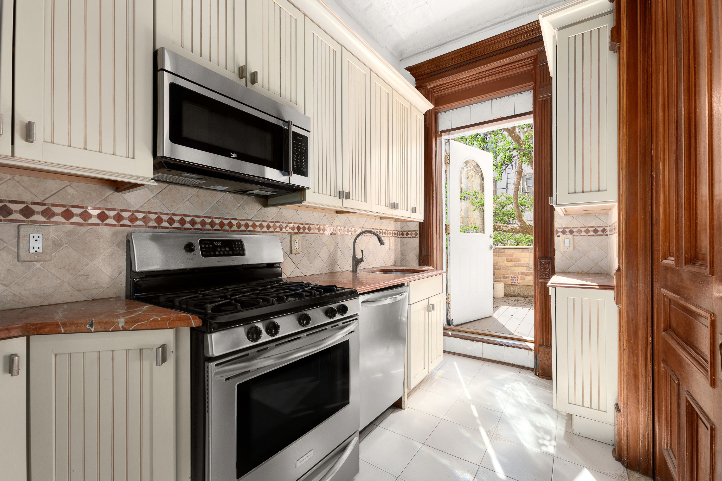 420 8th Street Brooklyn, NY 11215 - Photo 3 of 20 a kitchen with stainless steel appliances a stove a microwave and cabinets