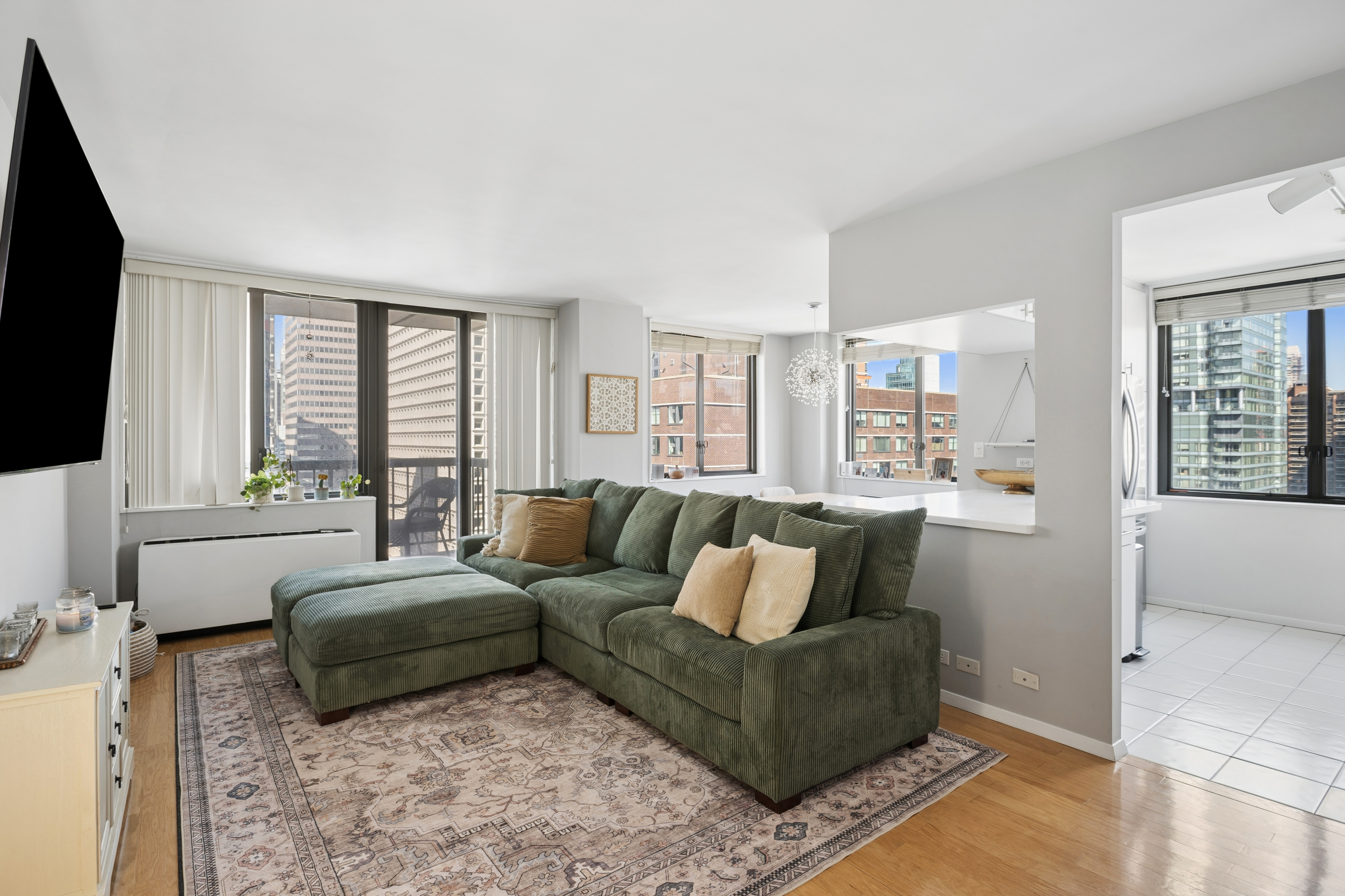 300 East 54th Street, Unit 29H Manhattan, NY 10022 - Photo 1 of 14 a living room with furniture and a flat screen tv