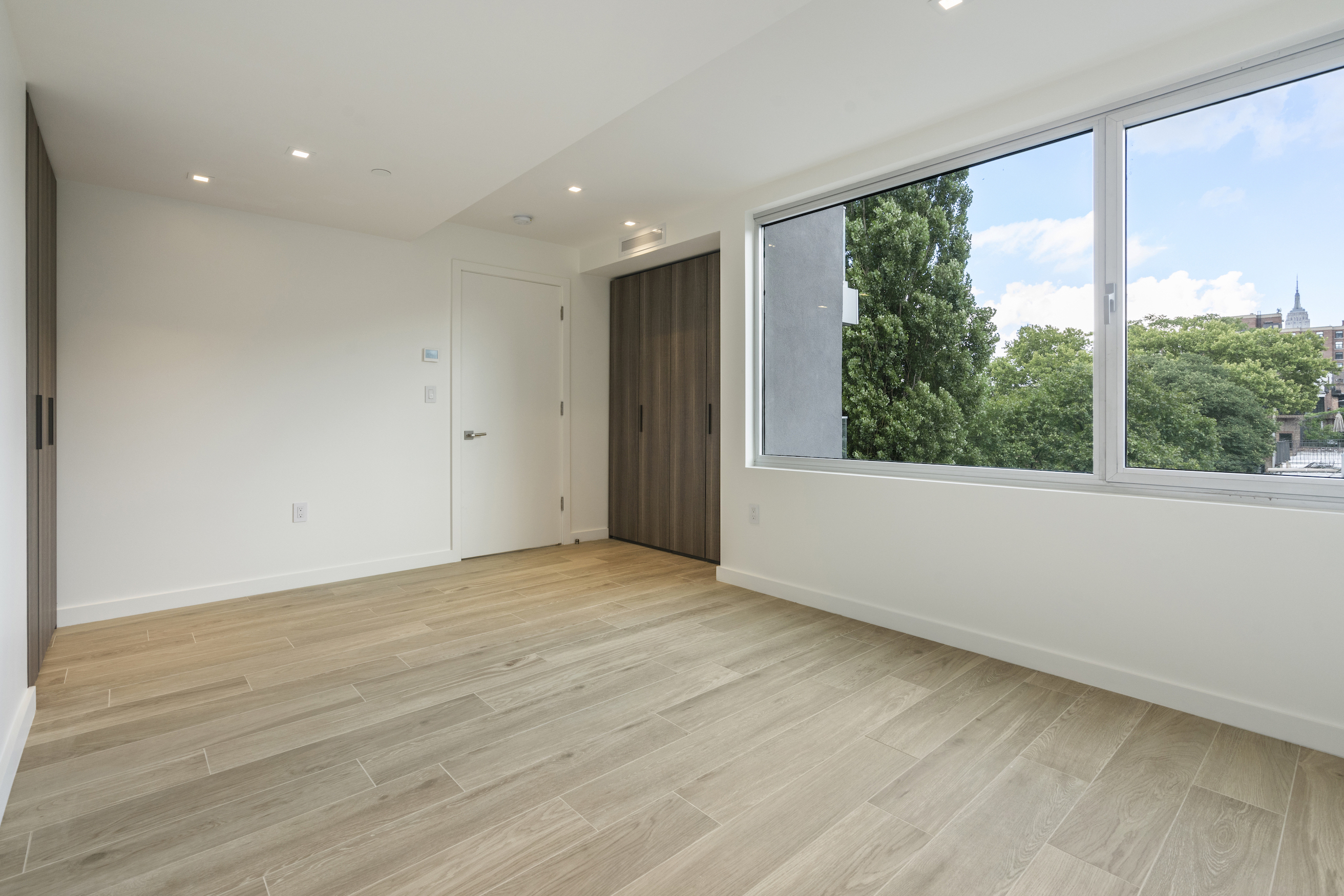 136 West Houston Street, Unit 6 Manhattan, NY 10012 - Photo 13 of 14 an empty room with wooden floor and windows