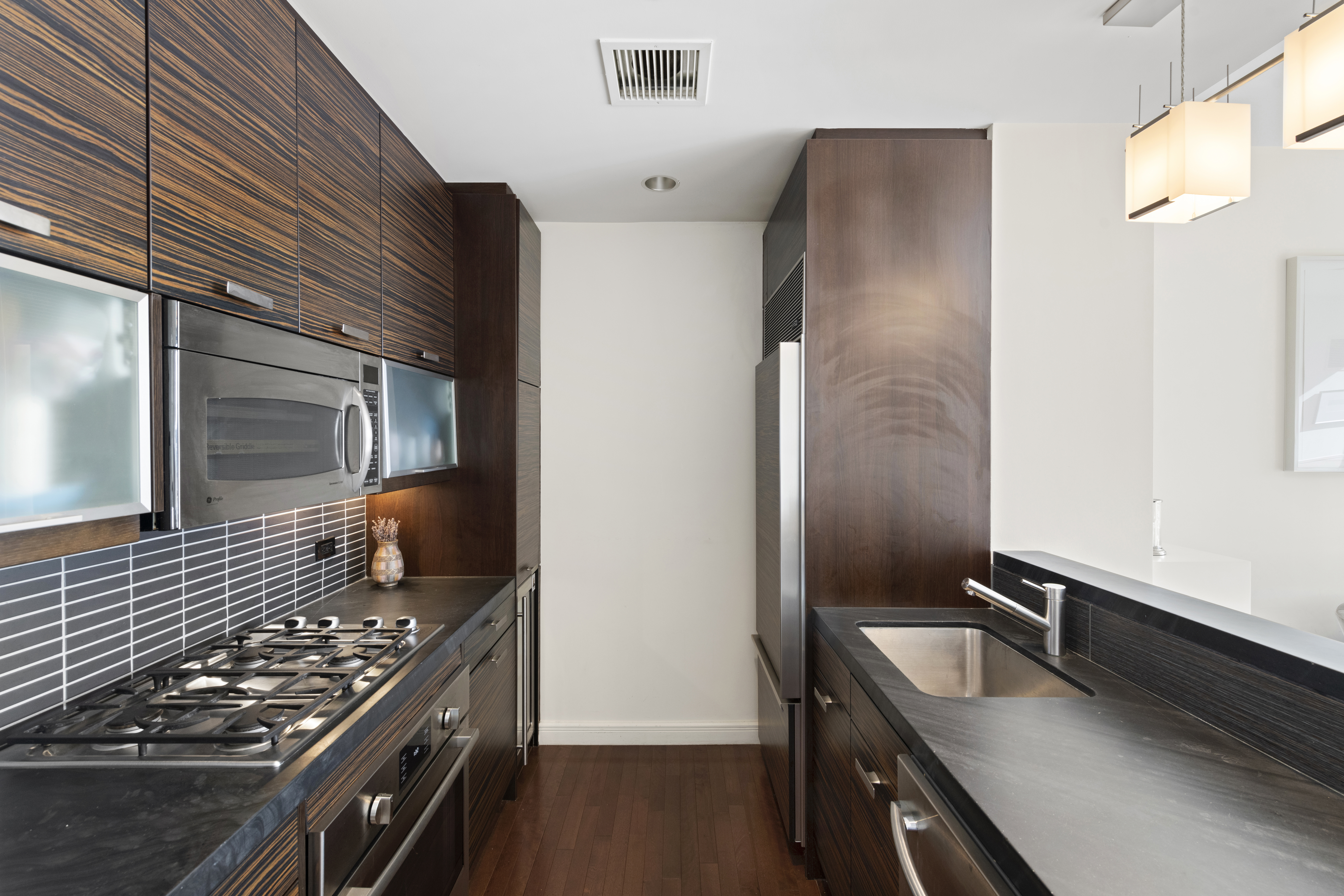 101 West 24th Street, Unit 12C Manhattan, NY 10011 - Photo 4 of 17 a kitchen with stainless steel appliances granite countertop a sink and a stove