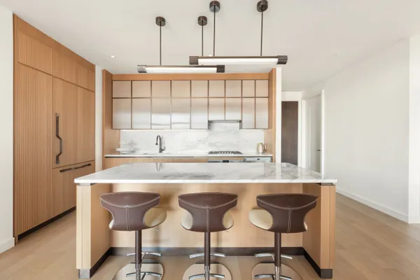 a kitchen with stainless steel appliances granite countertop a table chairs and a refrigerator