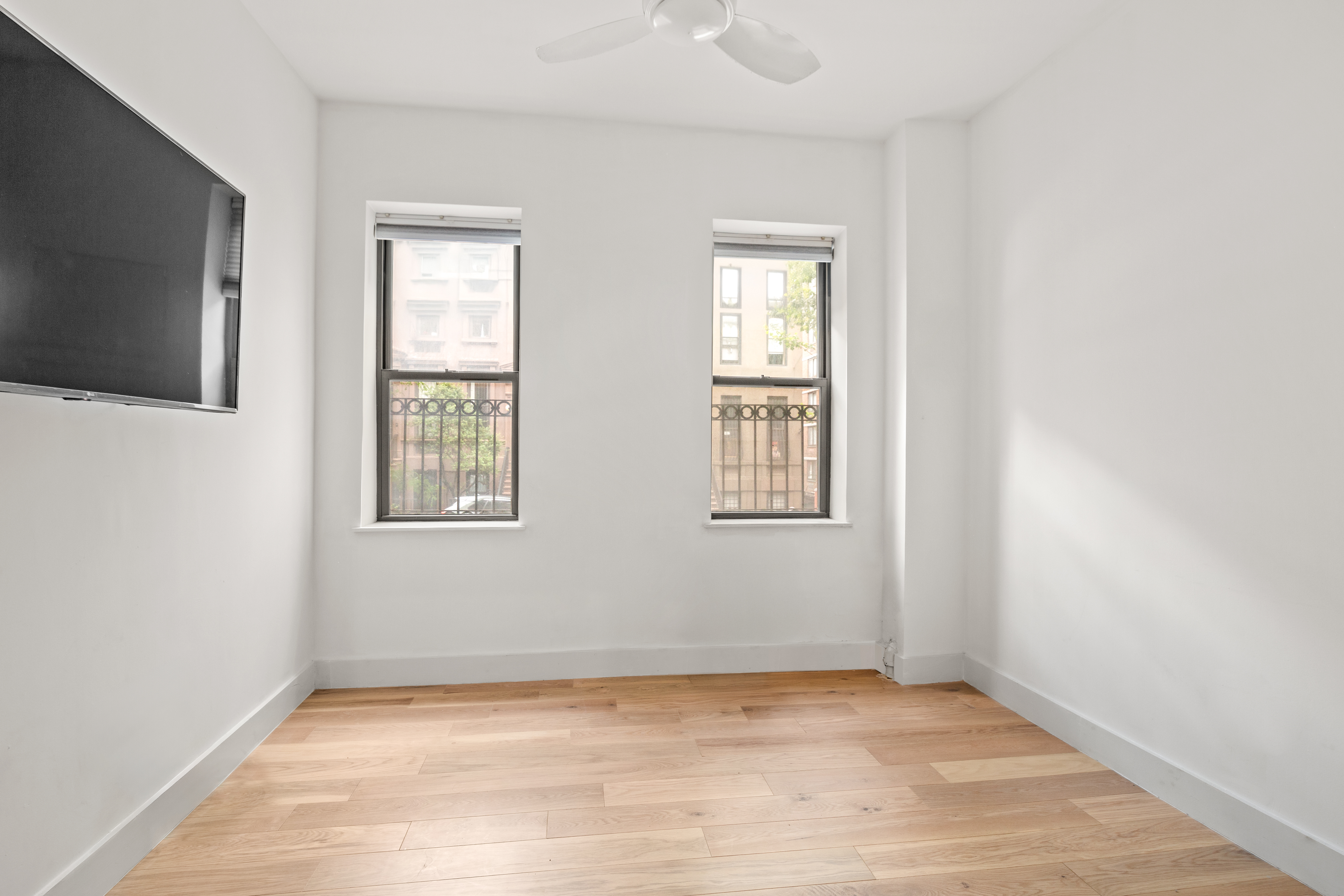 170 East 94th Street, Unit 1C Manhattan, NY 10128 - Photo 7 of 9 a view of an empty room with wooden floor and a window