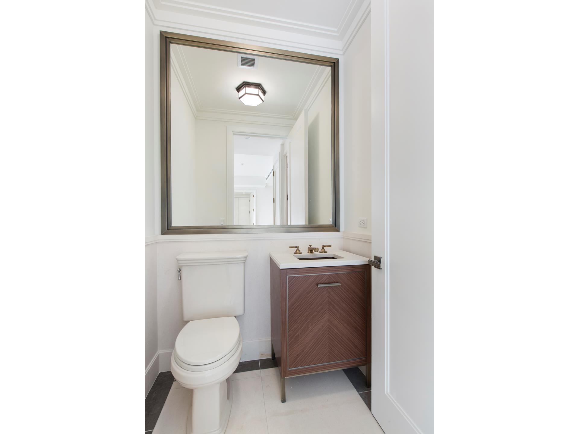 100 Barclay Street, Unit 13P Manhattan, NY 10007 - Photo 10 of 21 a bathroom with a toilet sink and mirror