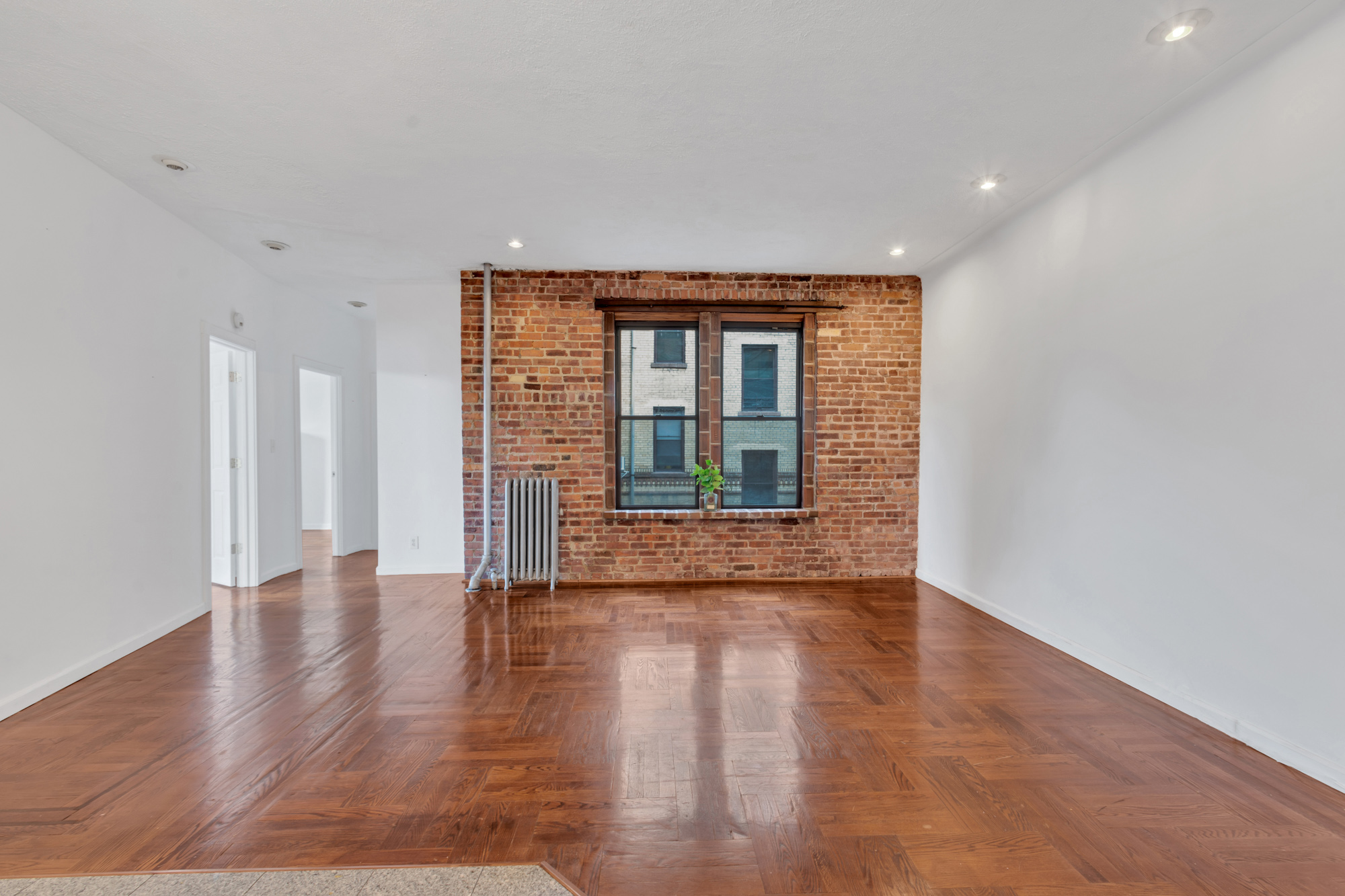 7609 4th Avenue, Unit B1 Brooklyn, NY 11209 - Photo 5 of 17 a view of an empty room with wooden floor and a window