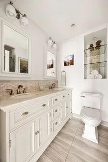 a bathroom with a granite countertop toilet sink and mirror