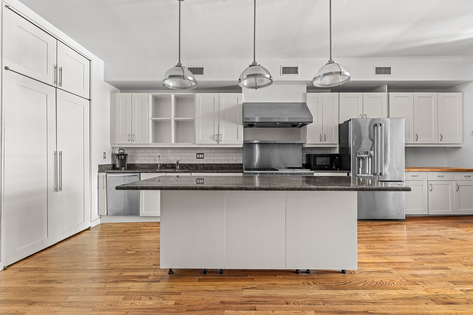 130 Watts Street, Unit 5N Manhattan, NY 10013 - Photo 2 of 11 a kitchen with stainless steel appliances granite countertop a sink a stove and a refrigerator