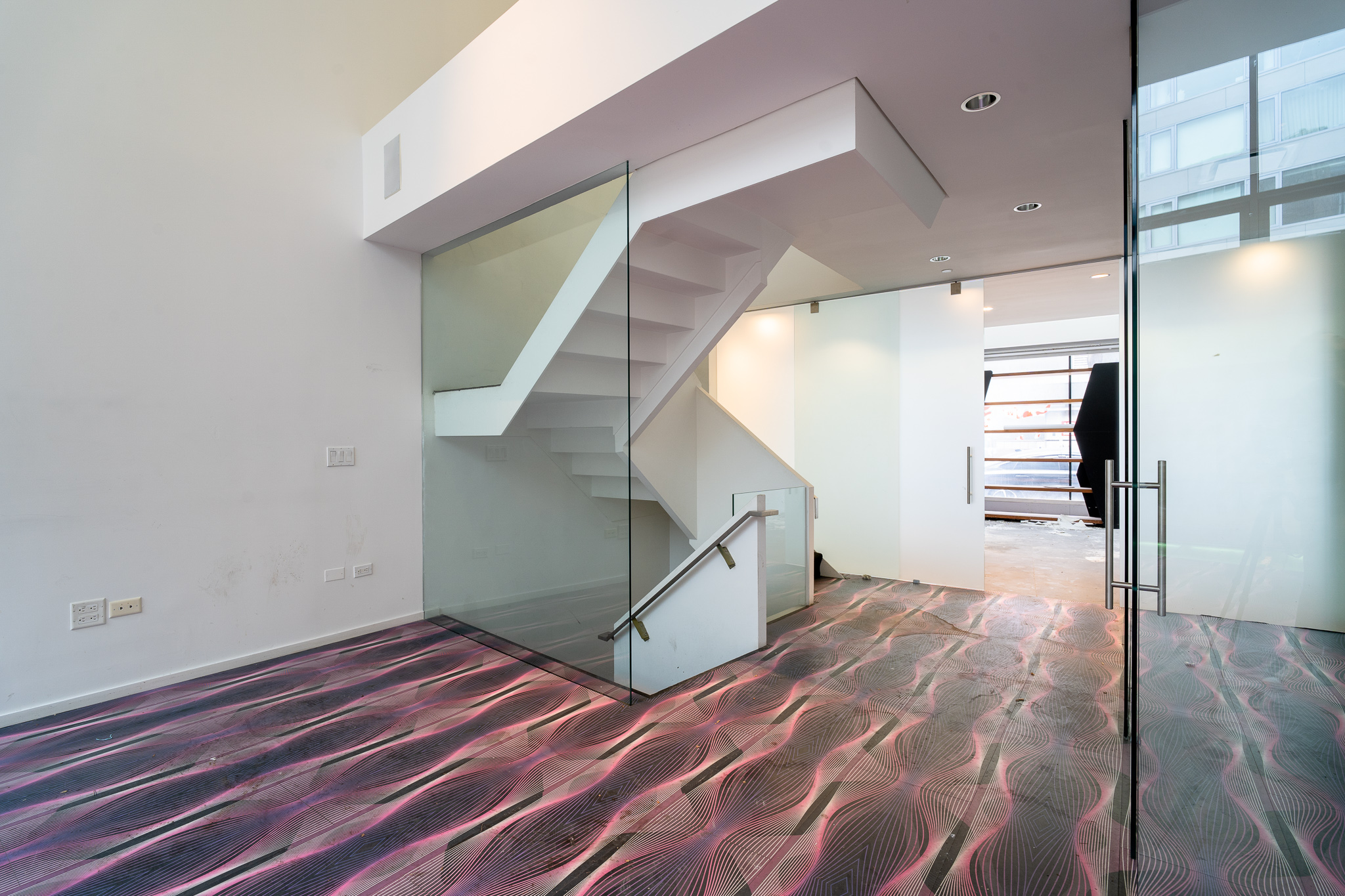 428 West 54th Street, Unit 1 Manhattan, NY 10019 - Photo 9 of 9 a view of an empty room with wooden floor and stairs
