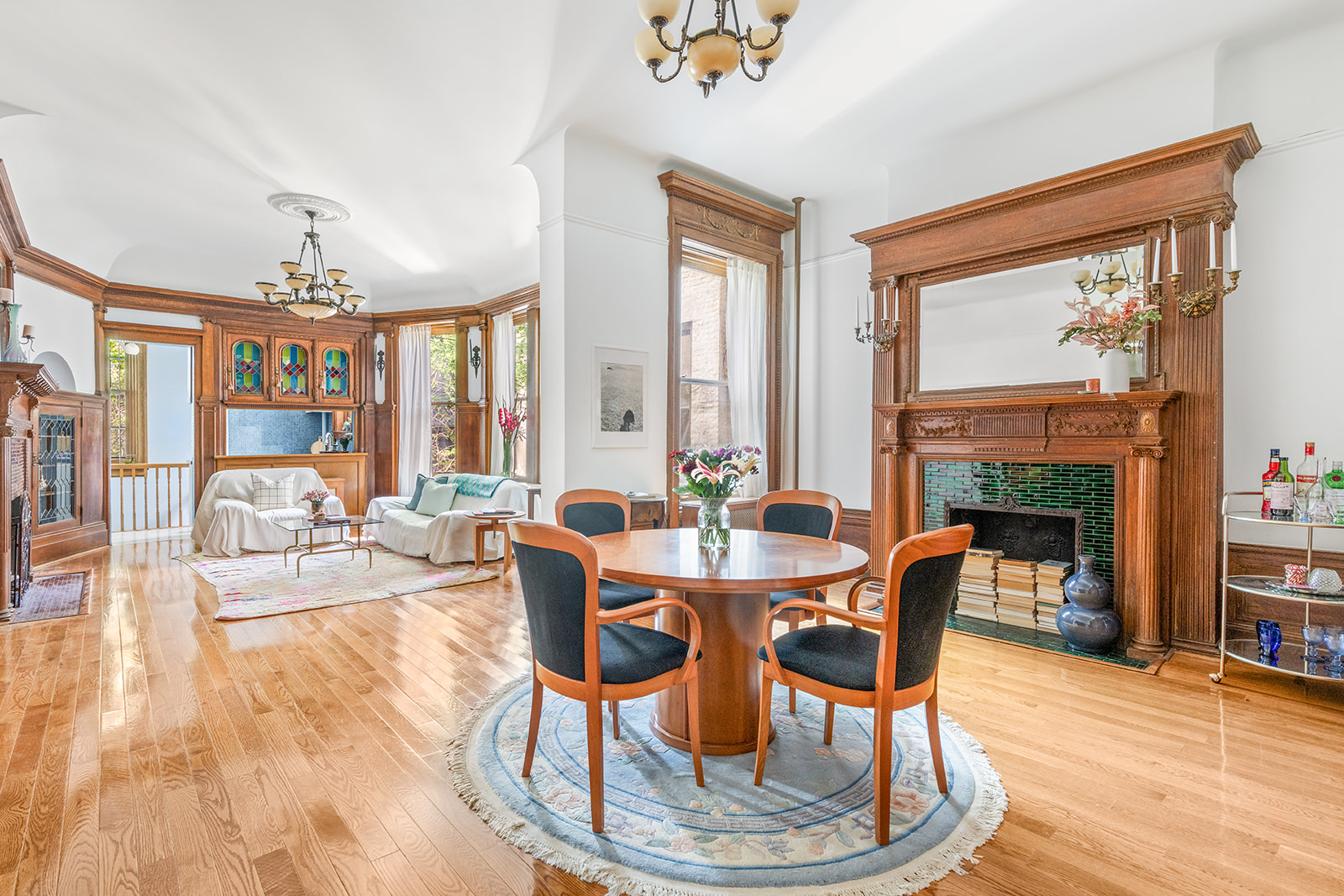 a dining room with wooden floor a chandelier a glass table and chairs