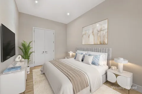 a bedroom with a large bed and a potted plant