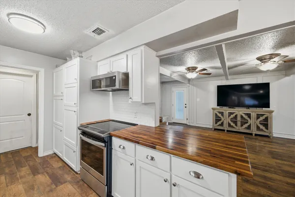 a kitchen with stainless steel appliances granite countertop a sink a stove and cabinets
