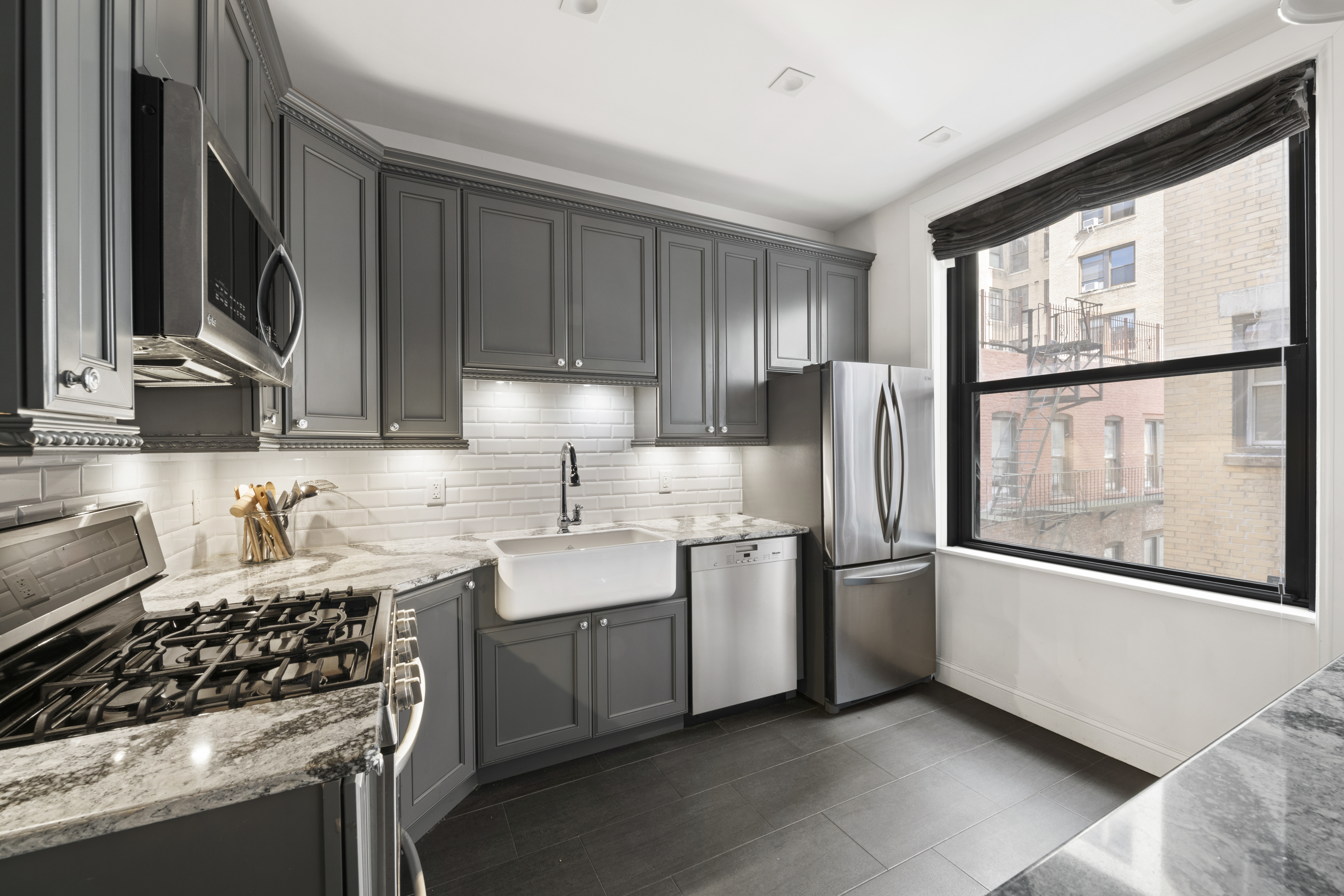 380 Riverside Drive, Unit 6A Manhattan, NY 10025 - Photo 3 of 10 a kitchen with stainless steel appliances a sink cabinets and a window