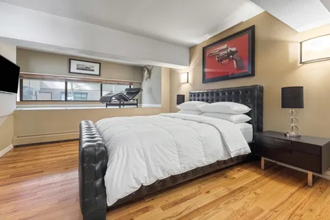 a spacious bedroom with a bed and a flat screen tv