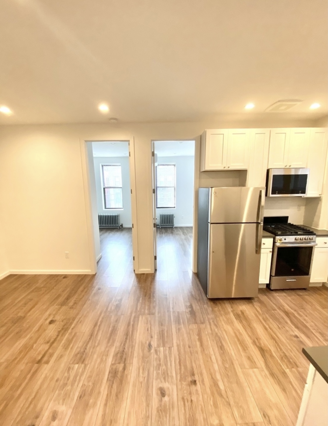 31-14 36th Street, Unit 3F Queens, NY 11106 - Photo 4 of 11 a view of a kitchen with wooden floor and electronic appliances